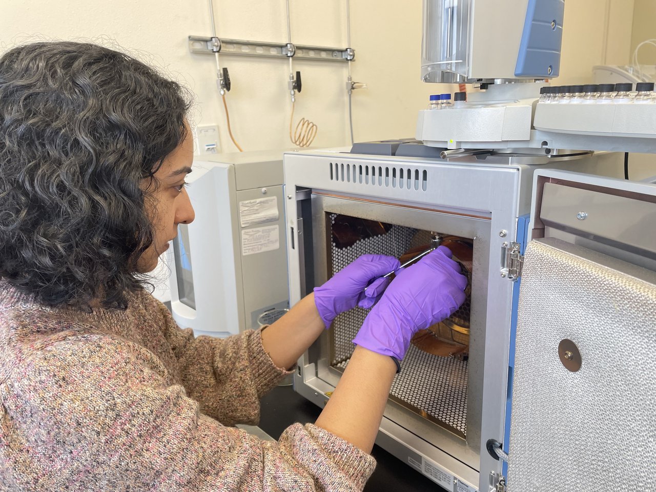 Bhattacharya performs maintenance on her gas chromatograph, a key piece of lab equipment that allows her to quantify the concentrations of leaf waxes in ancient sediments.