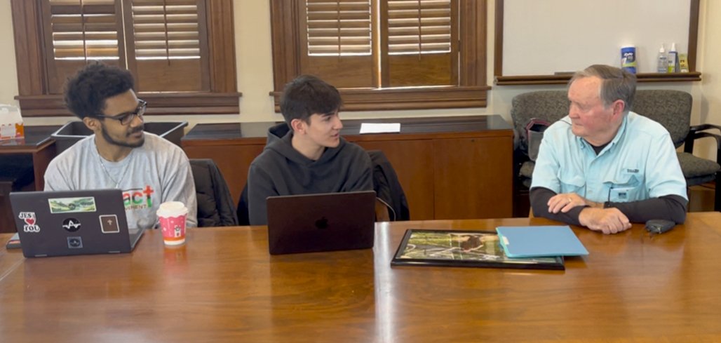 Three people seated at a table.