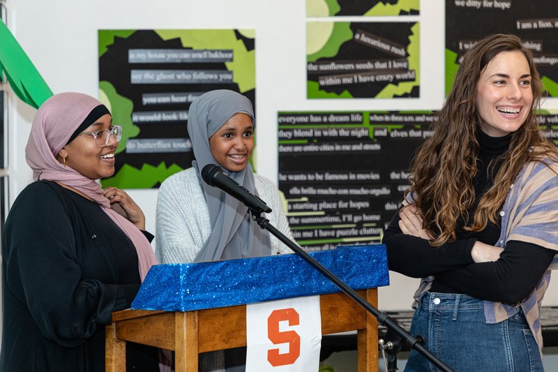 Three people standing around a podium.