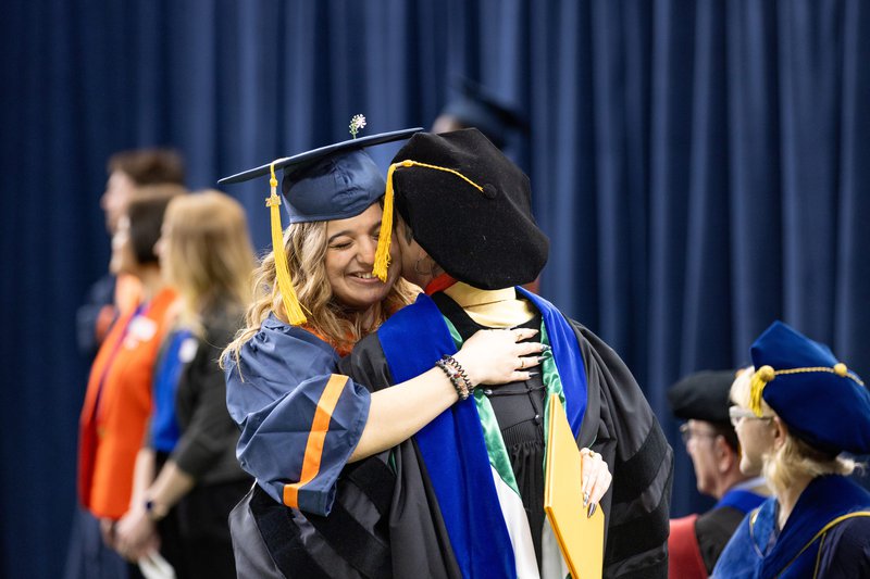 Student giving a hug before receiving their diploma at convocation 2024