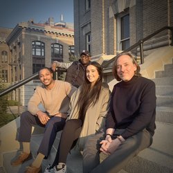 Four people sitting on steps.