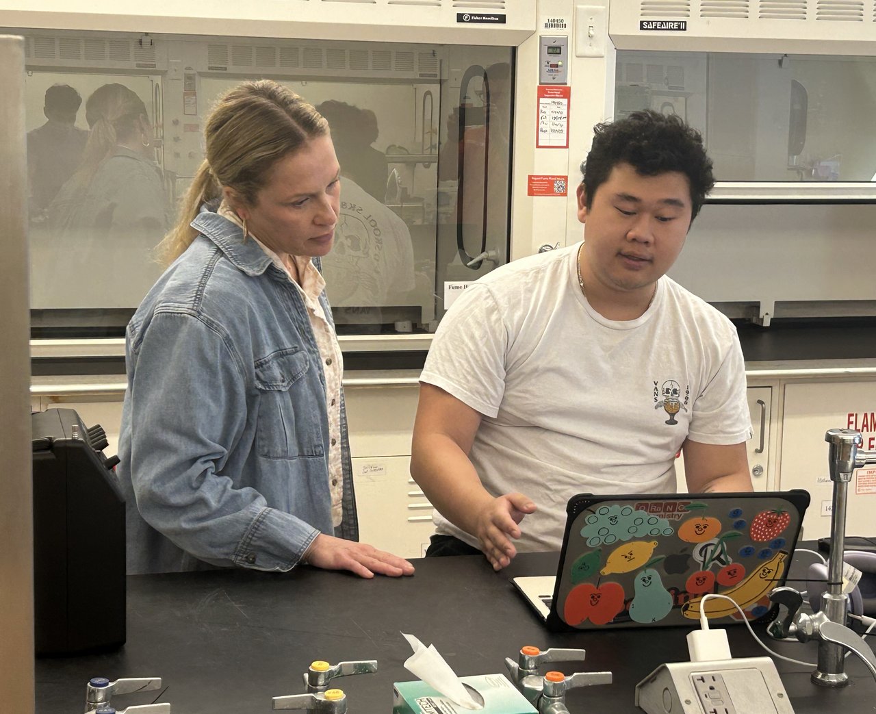 Two people staring at a computer.