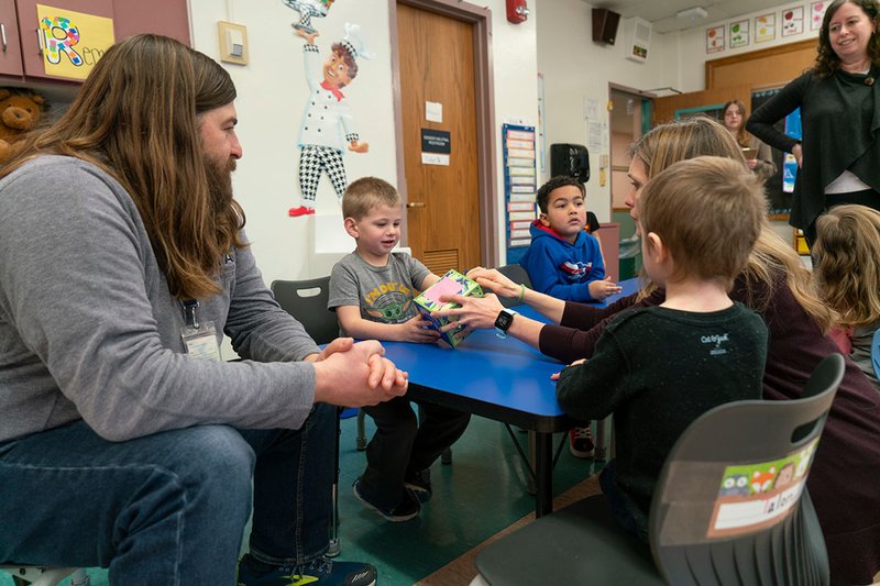 Adults working with children in a classroom.