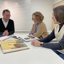 Mike Goode, Kate Holohan and Abigail Greenfield reviewing books containing ecologically related artworks.