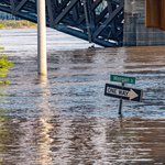 Flooded road with street signs just above the water line.