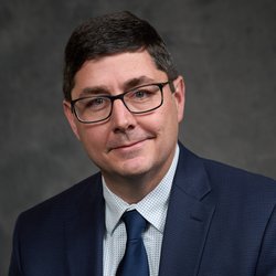 Man in a suit wearing glasses.