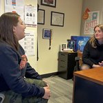 Two people having a conversation in an office.