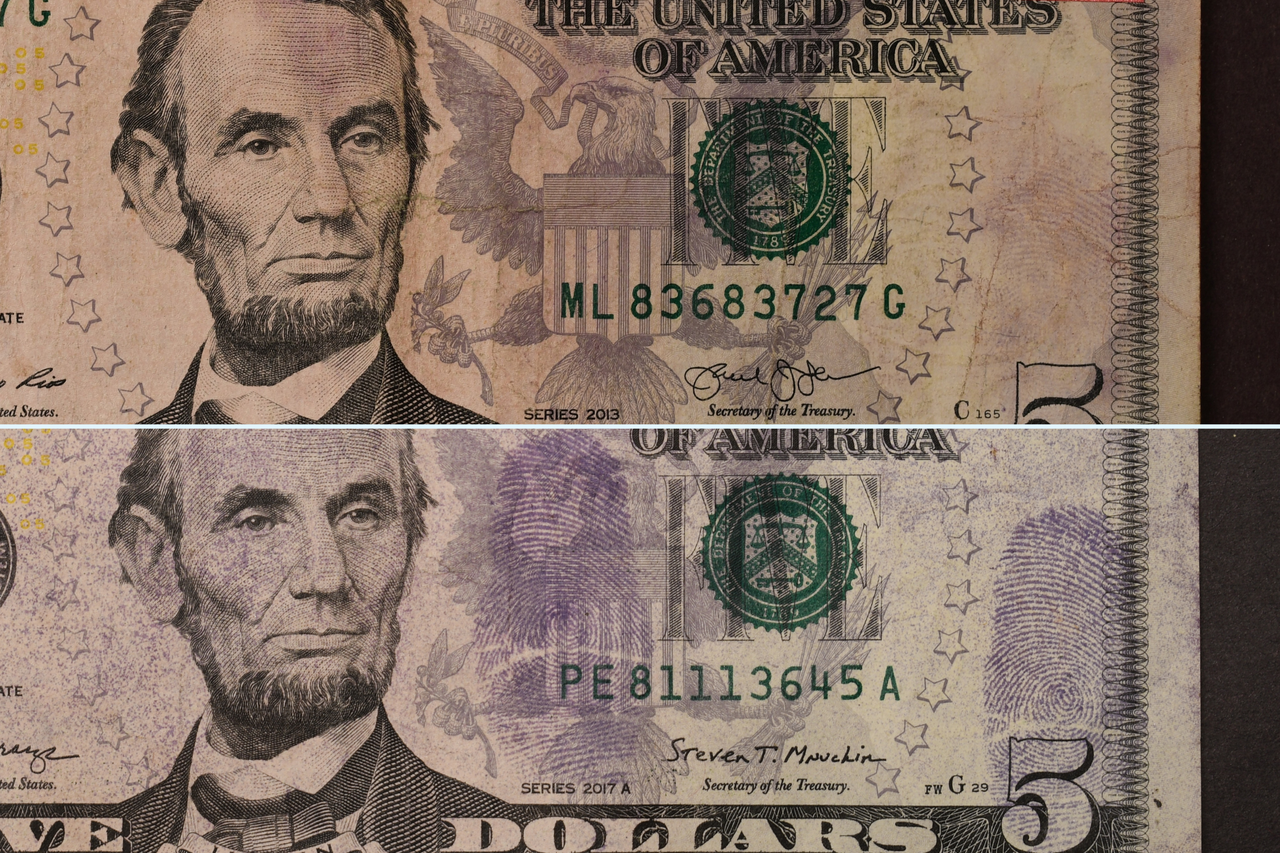 Two five dollar bills that have been scanned for prints.