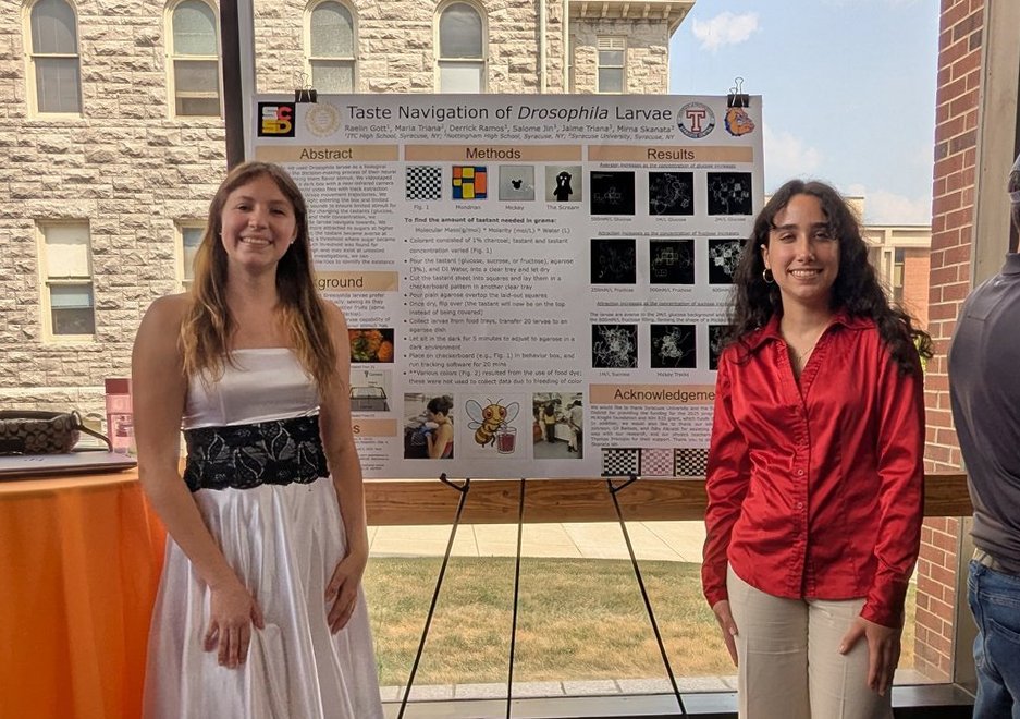 Two female students standing in front of a poster.