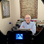 Person wearing glasses with a circlular light in the foreground.