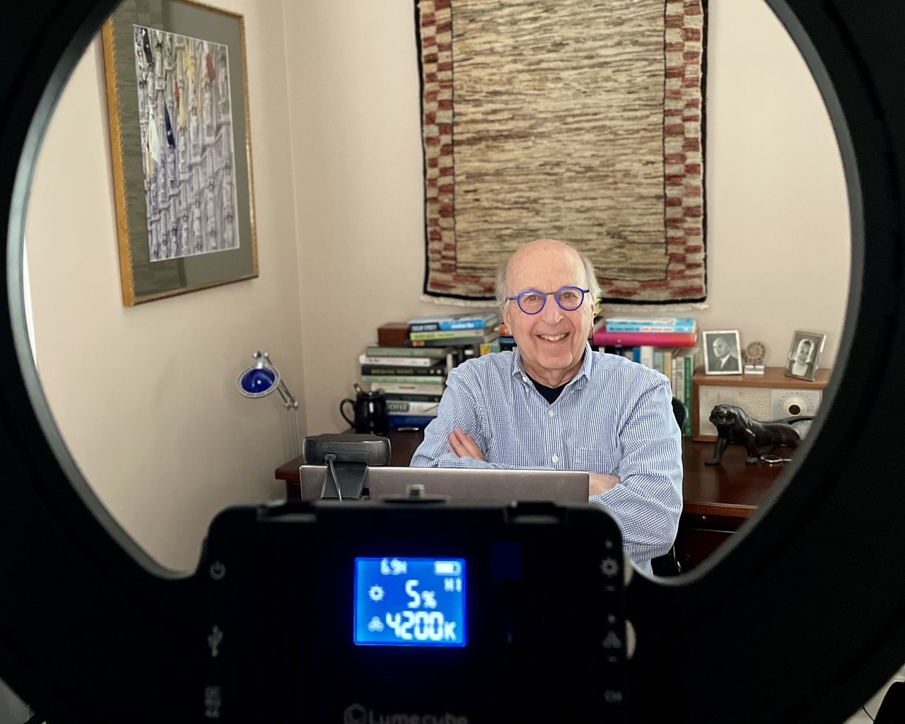 Person wearing glasses with a circlular light in the foreground.