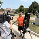 Person being interviewed by a news crew.