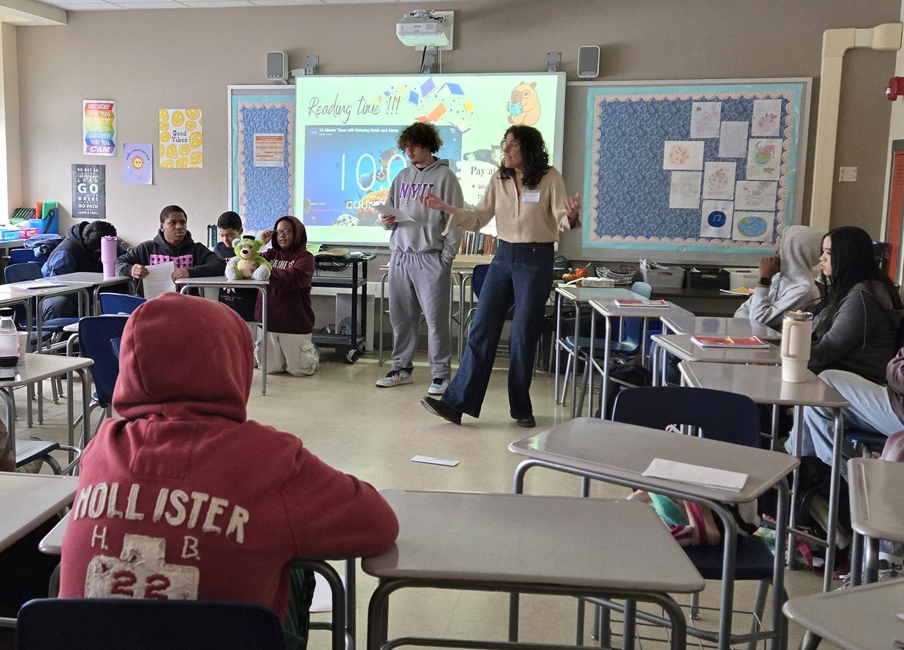 A teacher speaking with a classroom of students.
