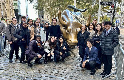 Stocks & Finance students at the bull statue on Wall Street