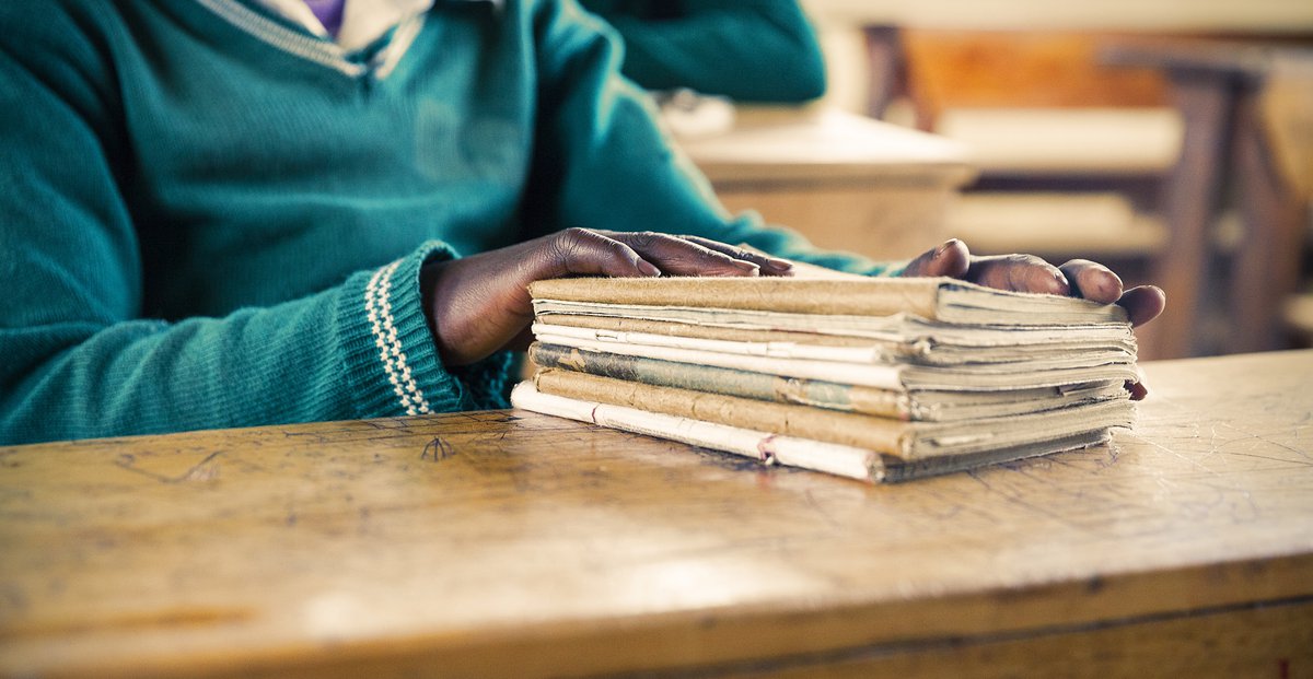 Student seated at desk with papers in the foreground.