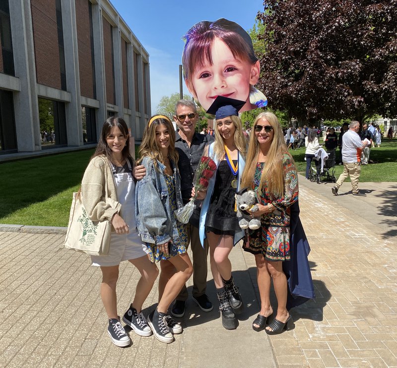 Student with family and cardboard cutout head 2023 Convocation