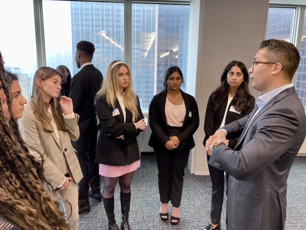 Students network with alum Enrique Estavez ’11 (right) at Morgan Stanley.