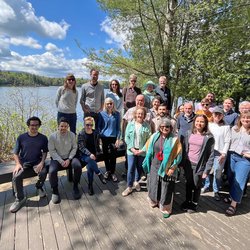 Group of people standing in front of a lake.