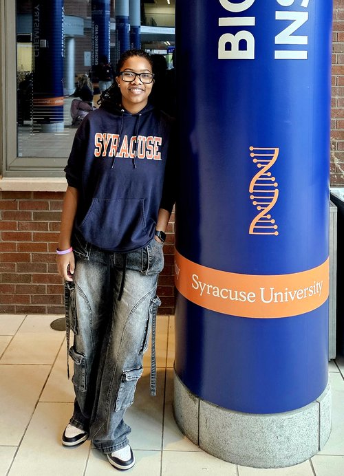 Person leaning on a blue pillar.
