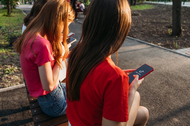 Three Girls Chatting on Smartphones.
