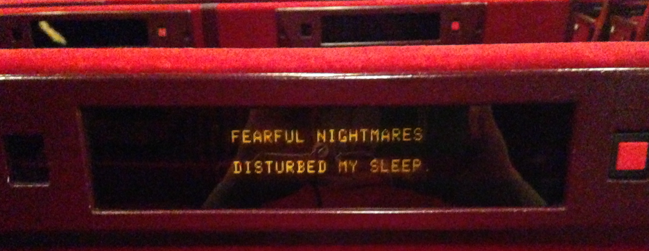 Subtitle screen on the back of a chair that reads fearful nightmares disturbed my sleep.