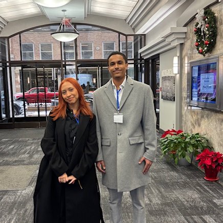 Two students standing in the lobby of a building.