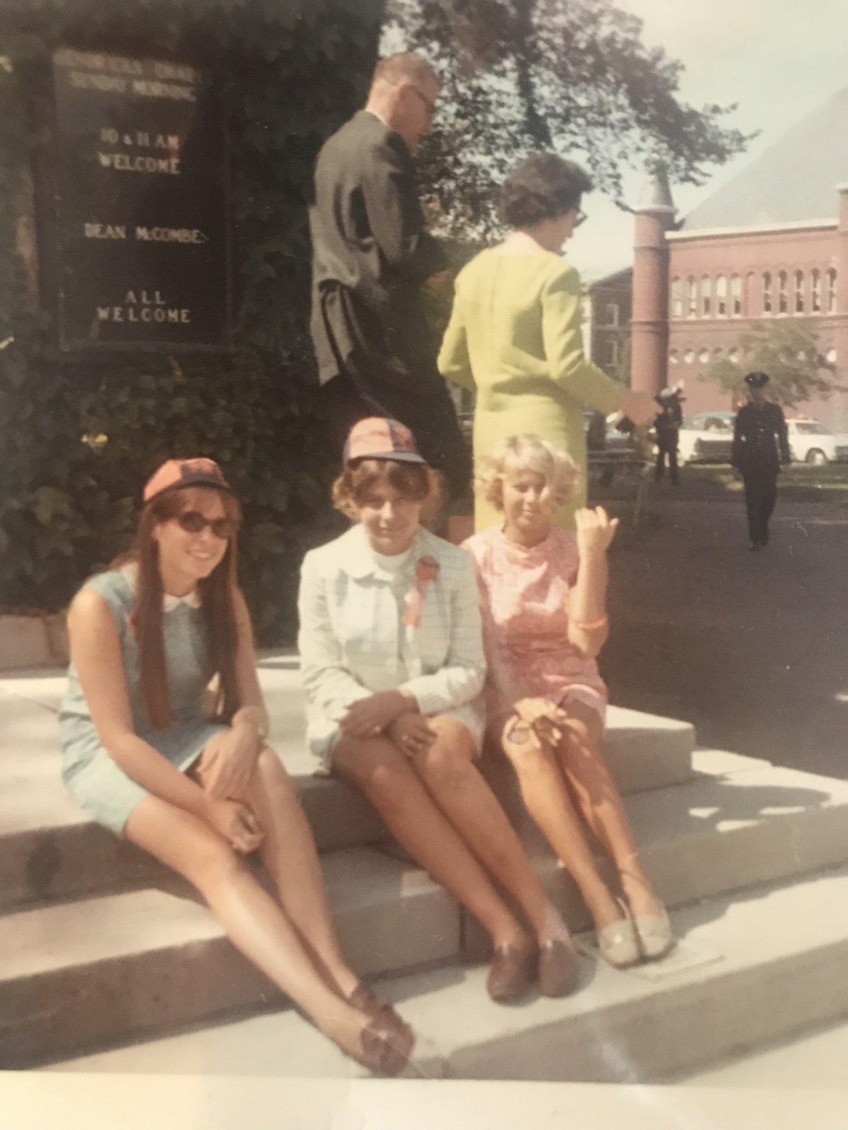 Photo from 1968 on the Syracuse University campus. Three girls sitting on steps outside.