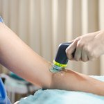 Arm receiving ultrasound therapy.