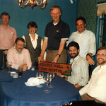 Group of people standing around a table.