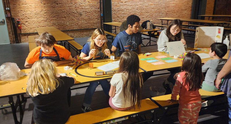 Students enrolled Linguistics at Work taught by Amanda Brown work with children at Syracuse's Museum of Science and Technology