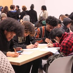 Students sitting at a table writing.