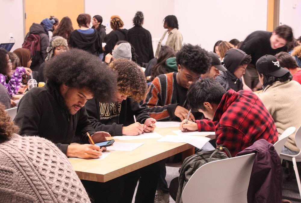 Students sitting at a table writing.