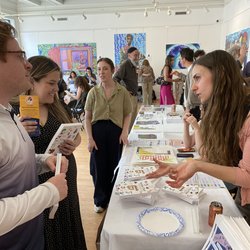 Three people talking around a table display.