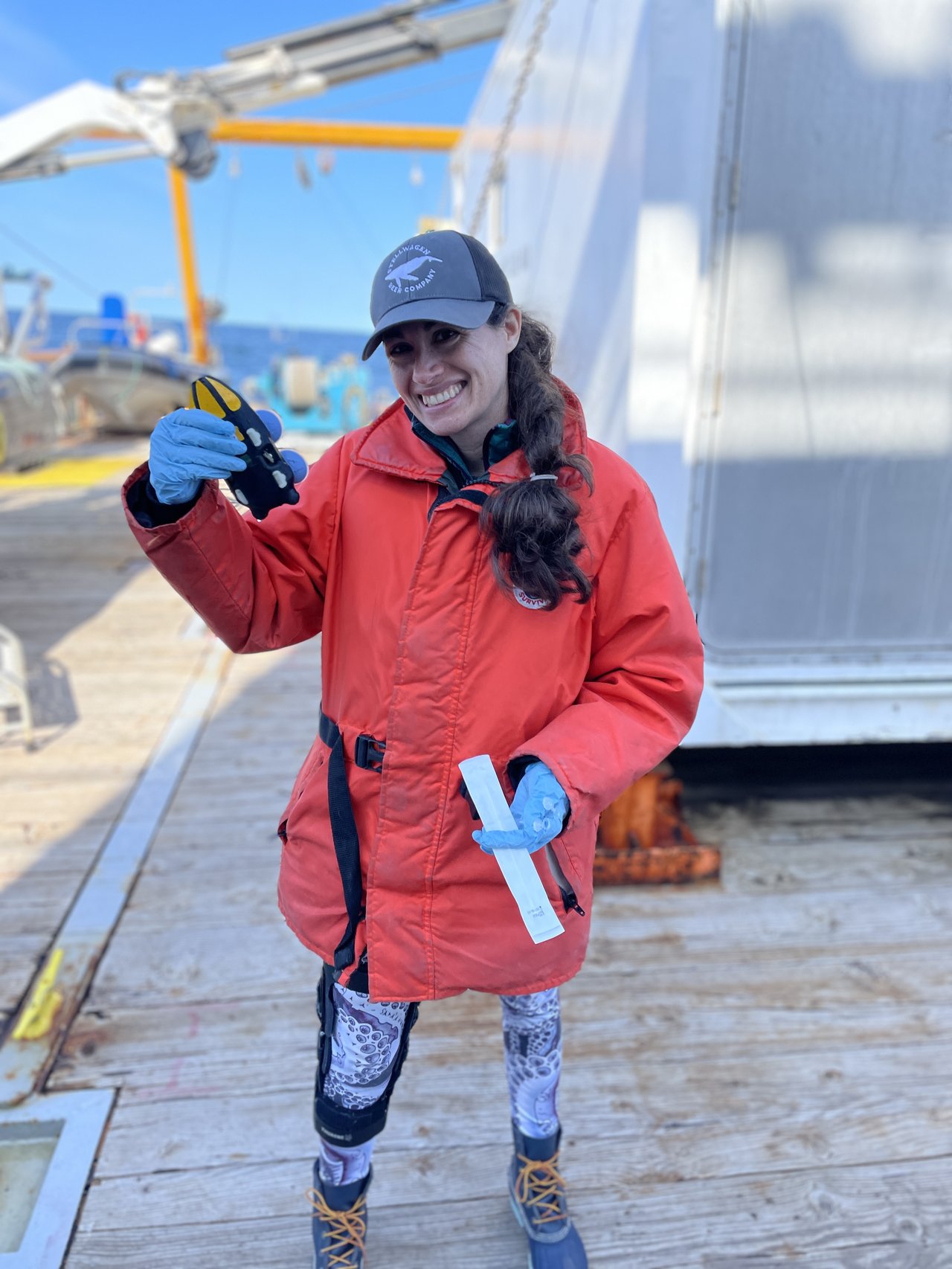 Woman holding a suction-cup biologging tag.