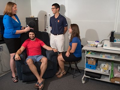 Professor Kathy Vander Werff, left, with her students, Sidorela Doci '16 (seated) and Kenny Morse (standing), work with a volunteer in Vander Werff's Auditory Electrophysiology Research Lab.
