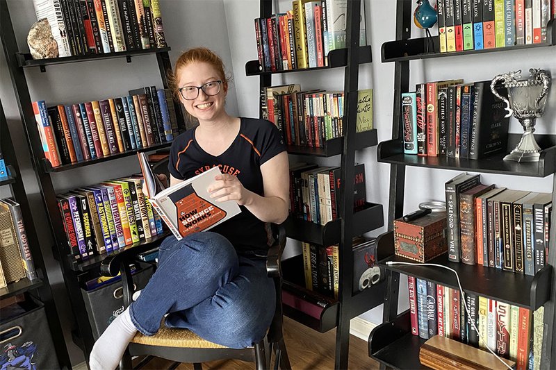 girl sitting in front of many books