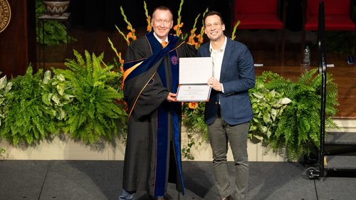 Person receiving an award from another person.