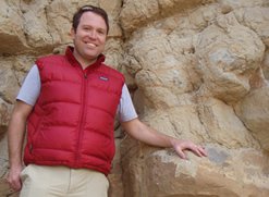 Christopher Junium in Colorado, posing with 94 million-year-old rock 