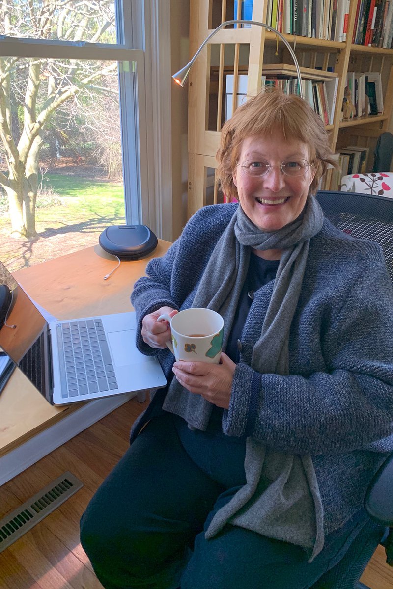 dean karin ruhlandt in chair with cup of tea and laptop