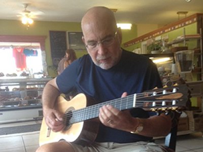 Donald Siegel playing guitar at Picasso's Pastries and Café
