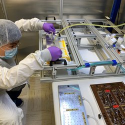 Physics graduate student Hangyi Wu gets ready to utilize a High Energy Physics-group designed vacuum pick-up tool for one of the delicate operations involved in assembling the instrumented staves.