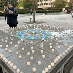 candles on a bench with a paper flower in the middle.