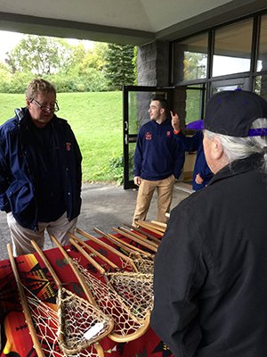 SU lacrosse coach John Desko examines handmade lacrosse sticks at the 2016 event