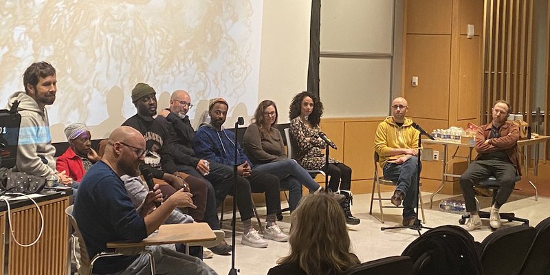 A group of people on stage talking about creative writing