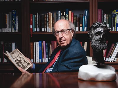 Man in office reading a book.