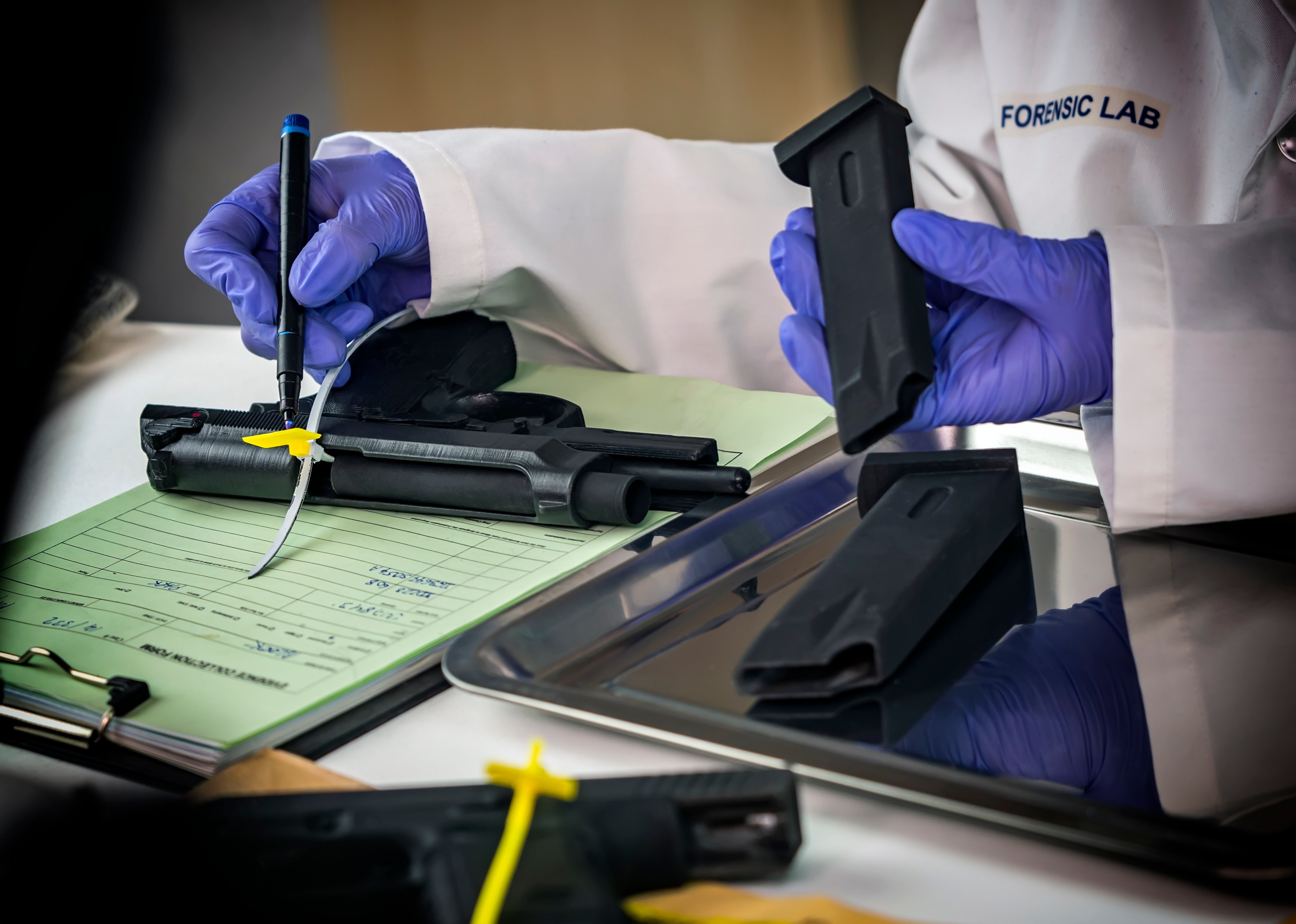 Police scientist notes serial number on sealed firearm in crime lab