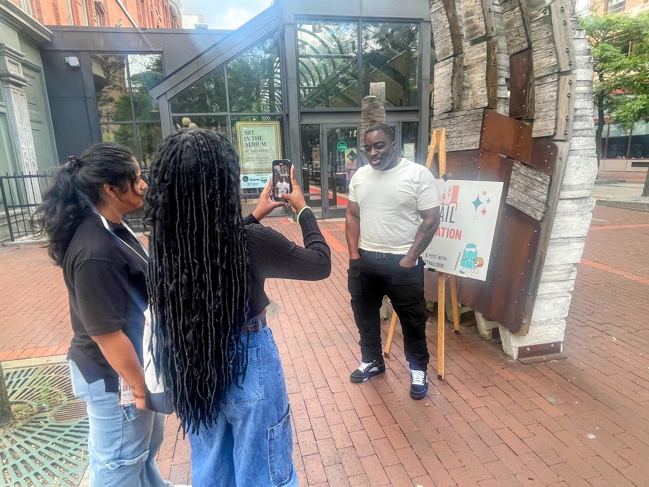 Person being interviewed on a sidewalk.